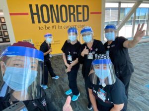 Six clinicians with face masks smile at the camera. Image from 2.1 VACC Newsletter.